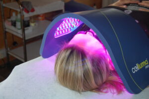 head of a lady lying on her back wih the celluma led light therapy unit over her face